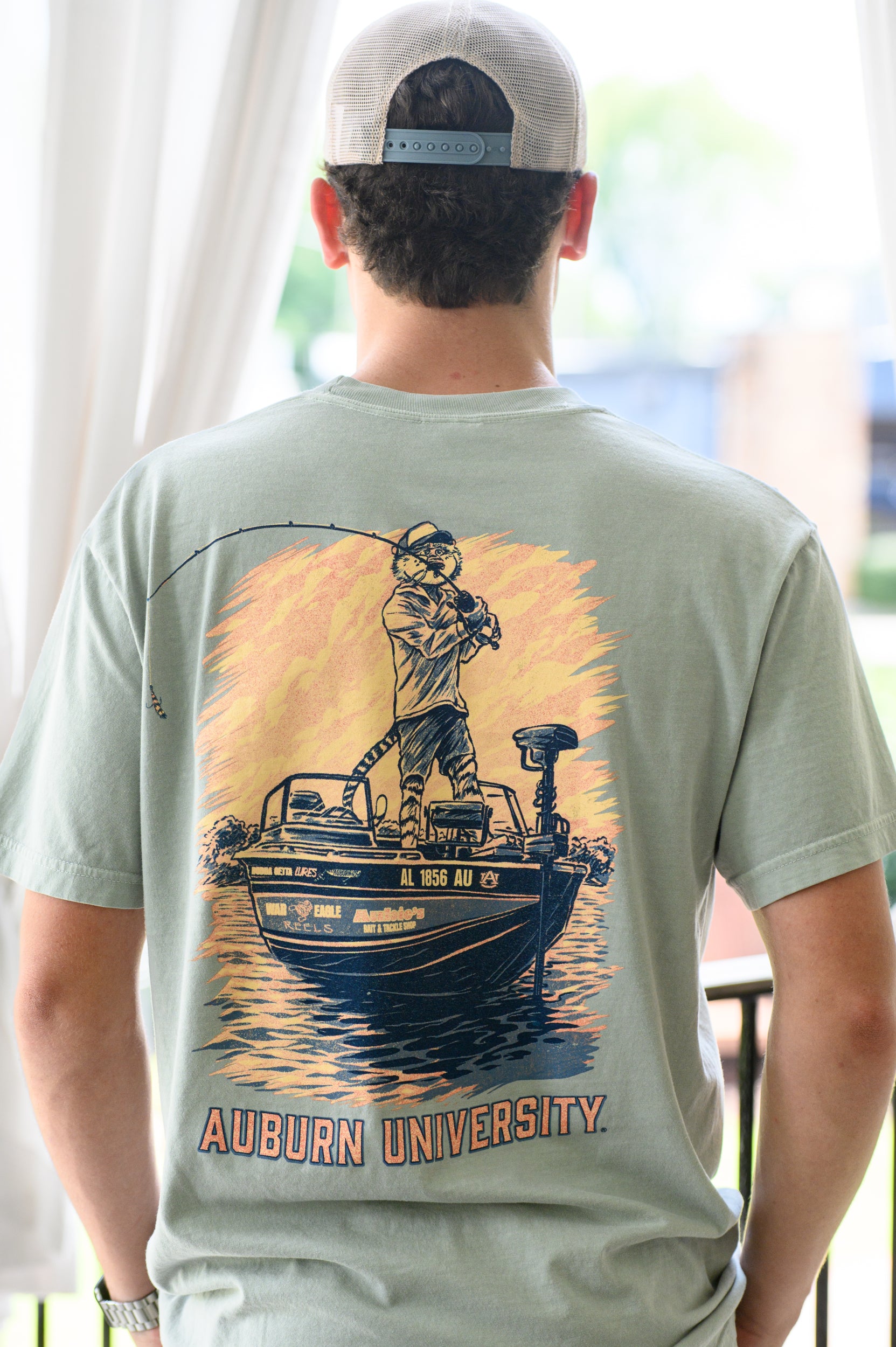 Auburn University Light Green T-Shirt with an image of Aubie bass fishing in a boat