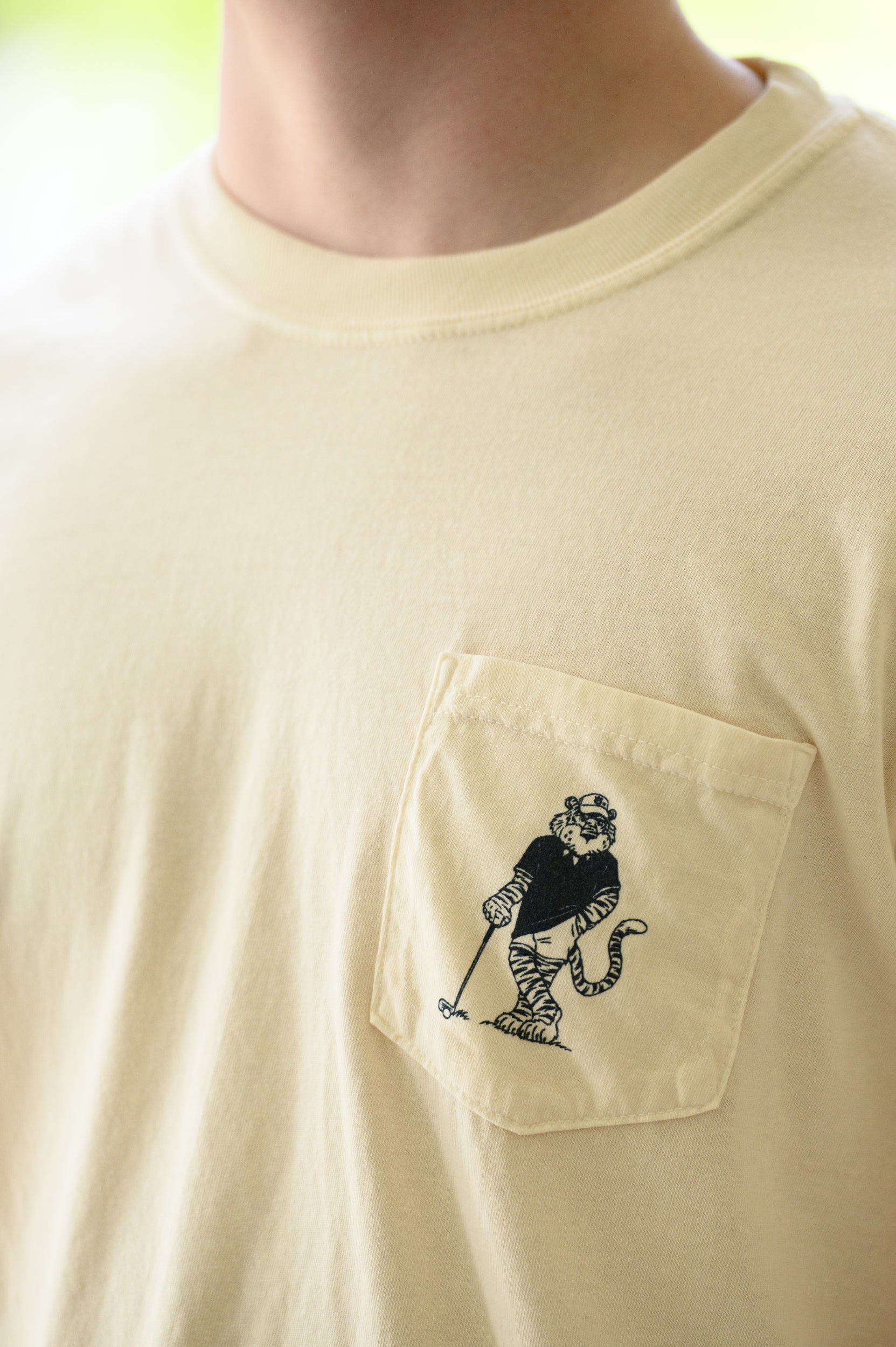 Auburn University Ivory T-Shirt with an image of Aubie leaning against a golf club between Navy Text "Auburn University" and "War Eagle"