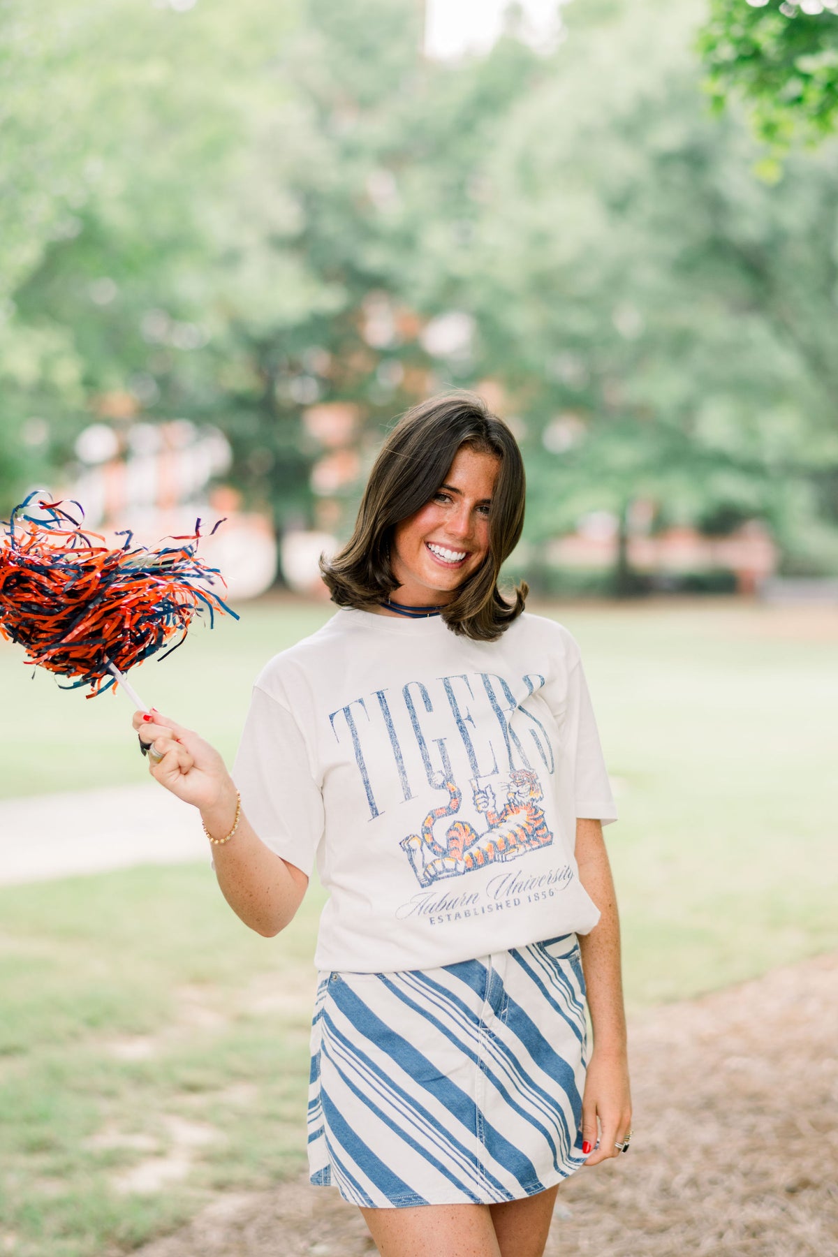Auburn University Ivory T-Shirt with navy text “Tigers” above Aubie laying down