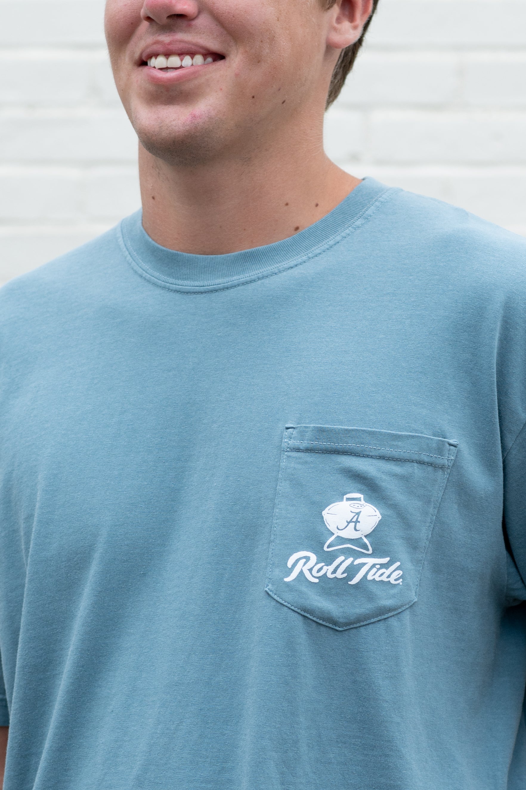 University of Alabama Blue T-Shirt with a drawing of Big Al grilling and the words “Roll Tide” written in the smoke