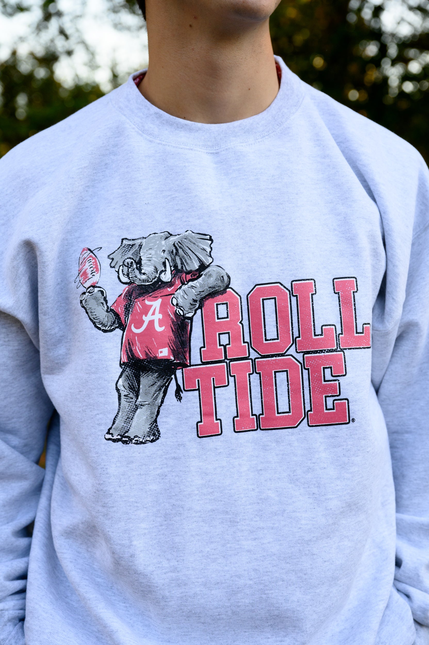 University of Alabama Gray Chill Big Al Sweatshirt with Red text "Roll Tide" and a graphic of Big Al leaning against the "R" of "Roll"