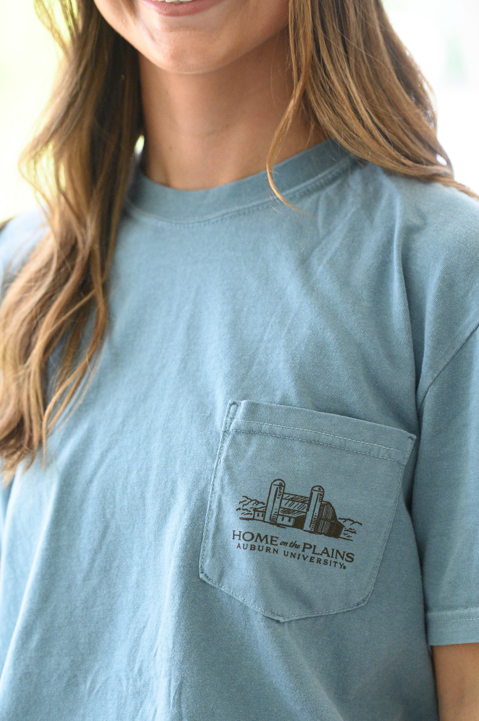 Auburn University Blue T-Shirt with an image of Aubie wearing cowboy clothes and watching over cattle at sunrise above Black text “Home on the Plains”