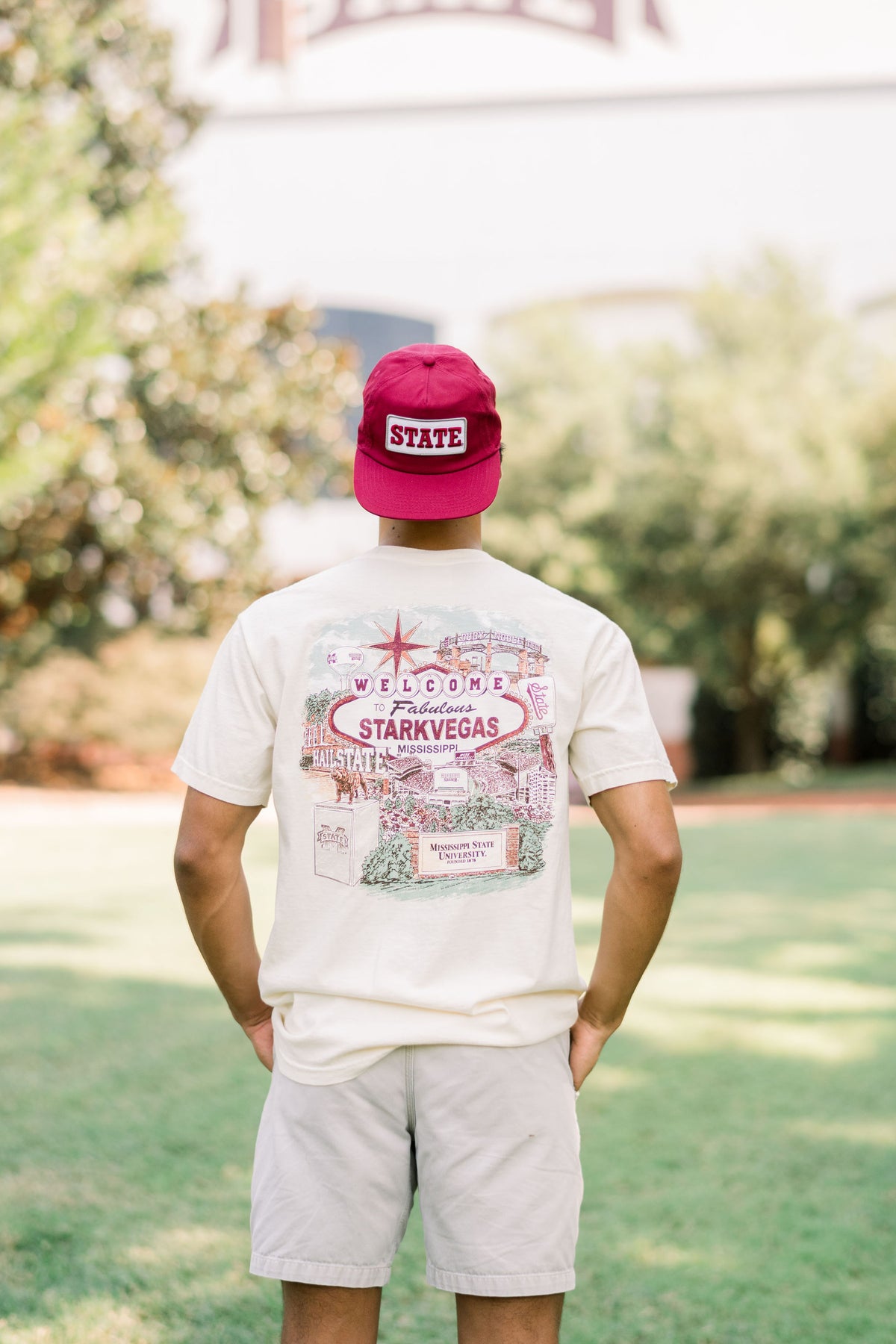 Mississippi State Ivory T-Shirt with an image of a Vegas- Style sign with text, “Welcome to Fabulous Starkvegas” in front of a collage of Mississippi State icons suck as Bully and the Davis-Wade Stadium