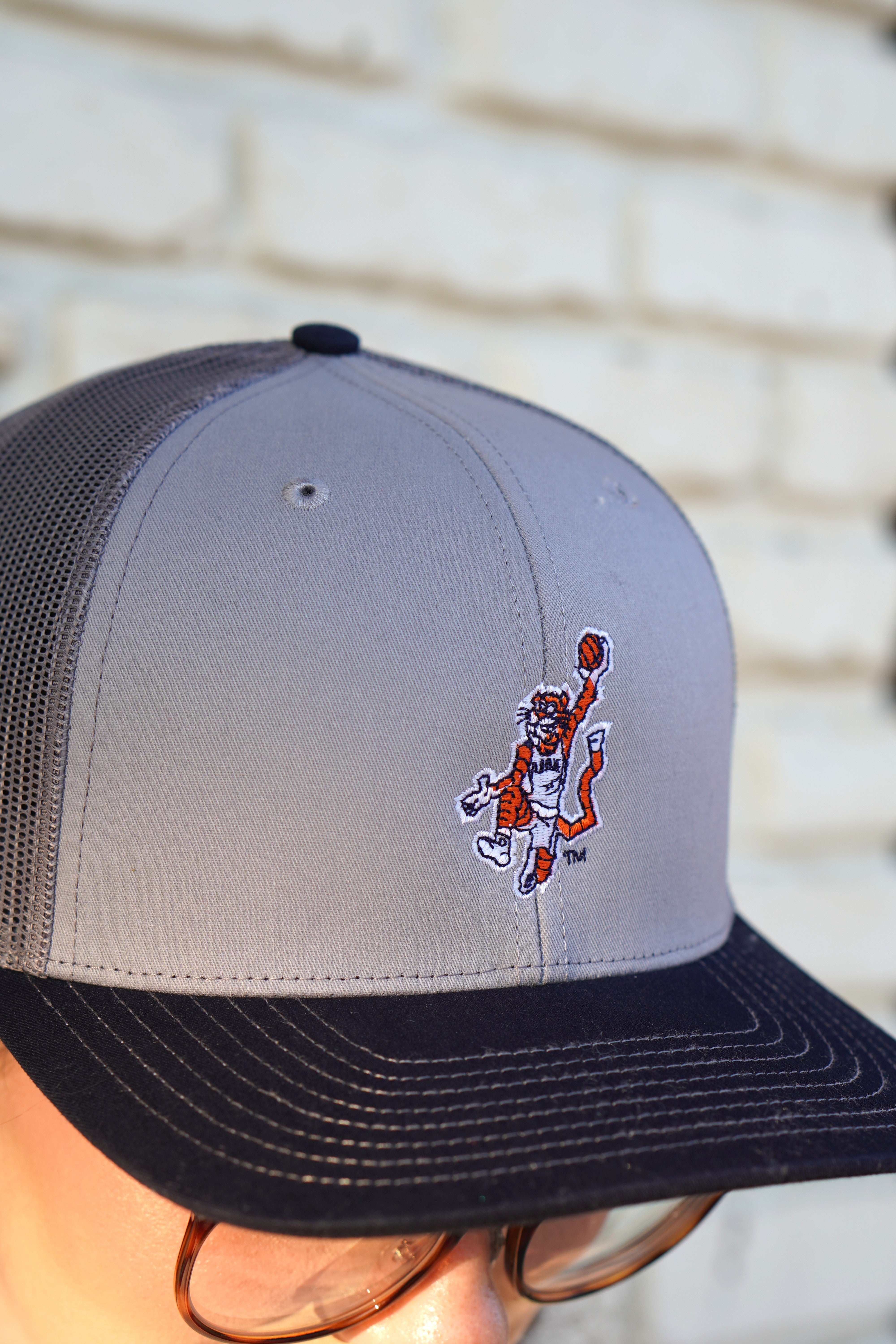 Auburn University Grey and Navy Trucker Hat with the Original Aubie basketball logo on the front, featuring a gray crown and black visor.