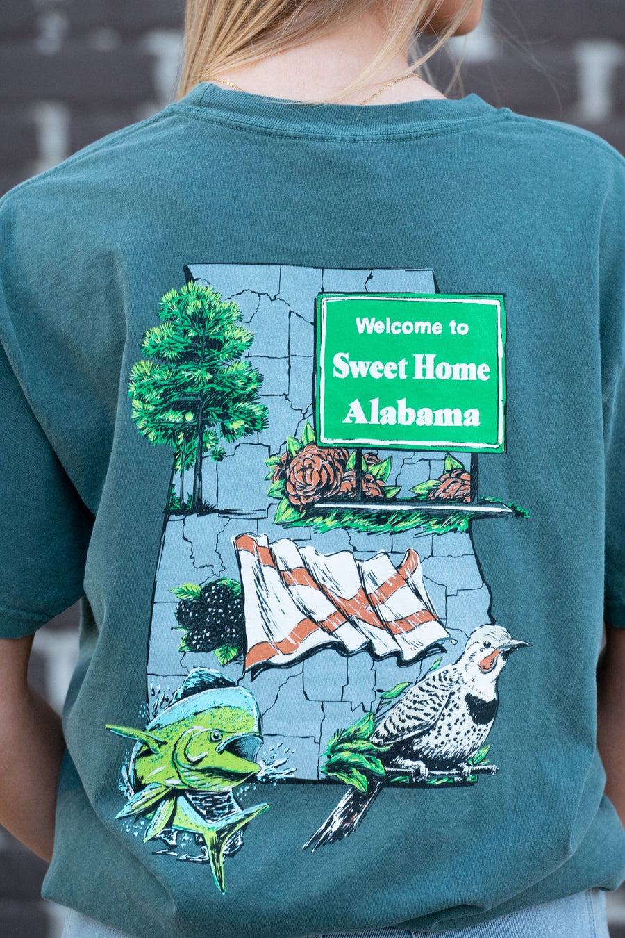 Blue Spruce Sweet Home Alabama T-Shirt with a graphic design that includes the state bird, flag, flower, and other elements representing Alabama.